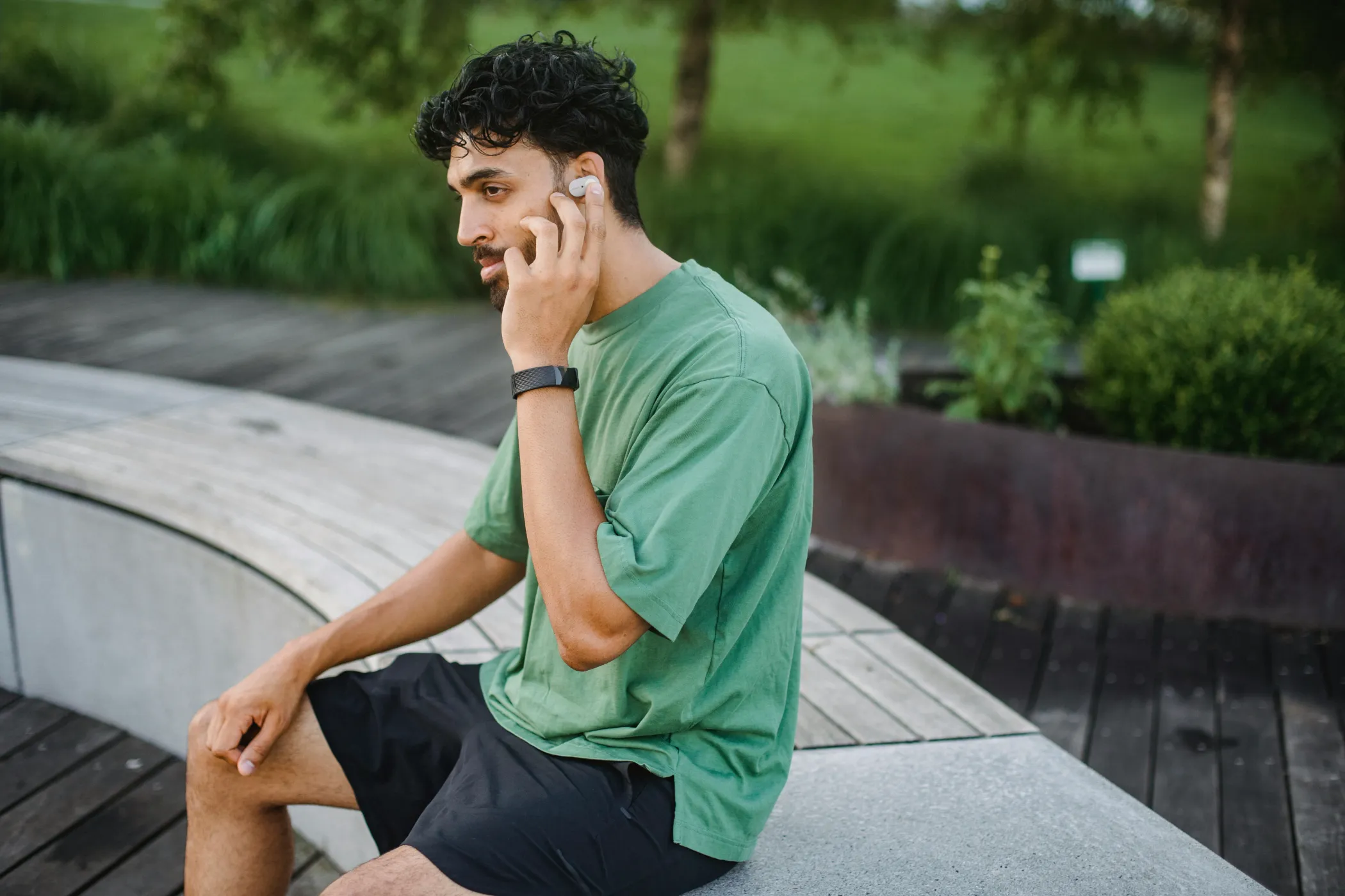 A man sitting down with a fitness watch on his wrist